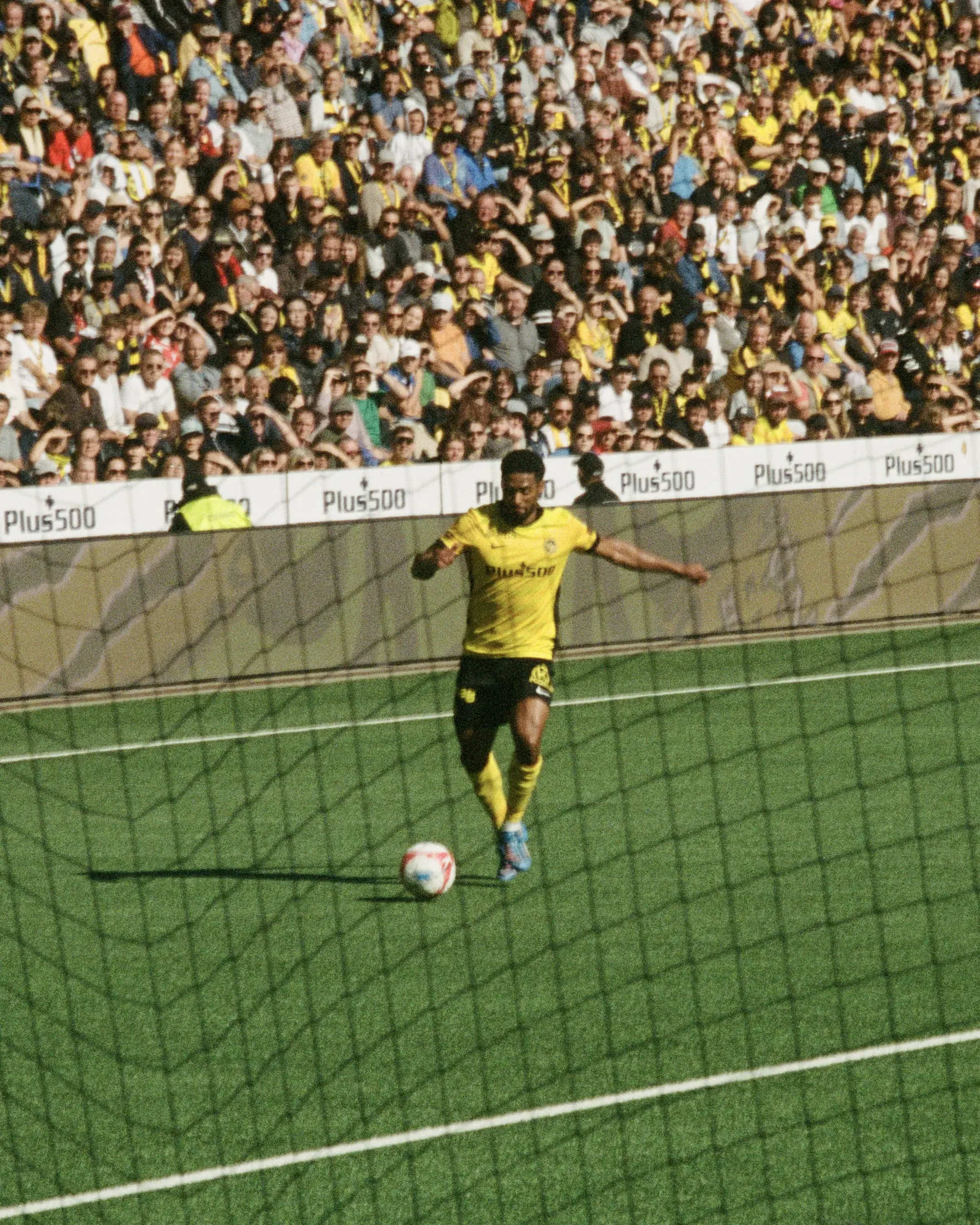 Spieler mit Ball vor der vollen Tribüne
